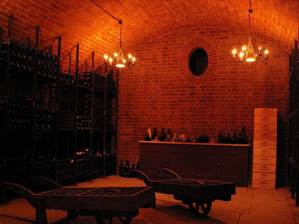 Brick wine cellar with bottle racks and a central table