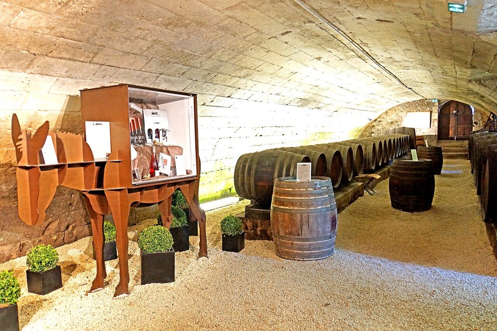 Wine barrels and a display rack in a vaulted cellar